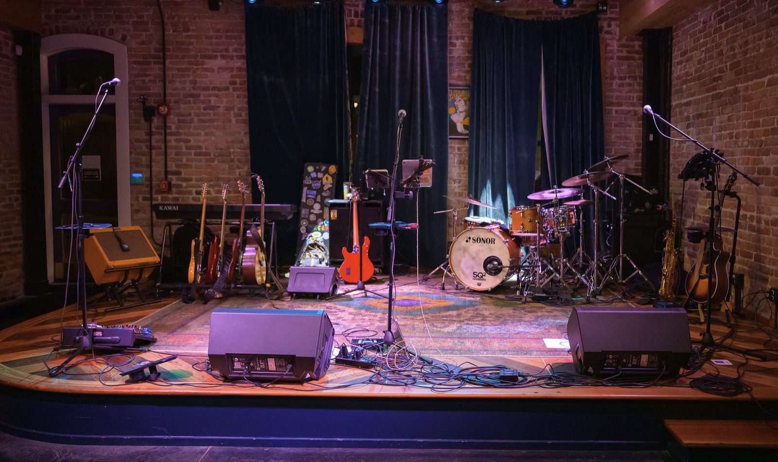 A local Nassau County stage set with instruments — guitars, drums, bass — waiting for the show